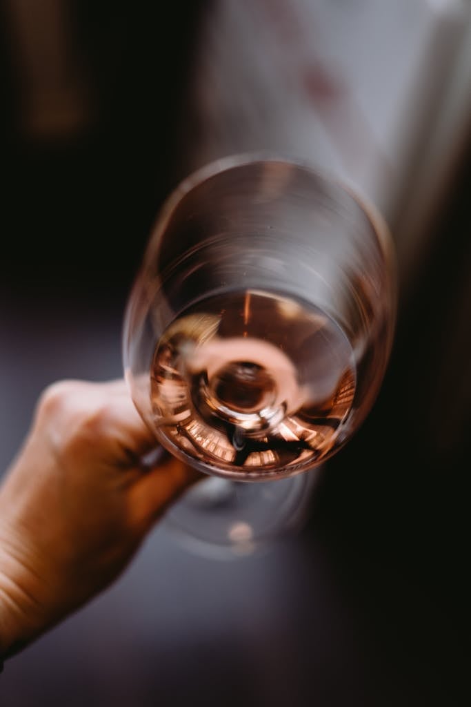 Crop person holding glass of wine